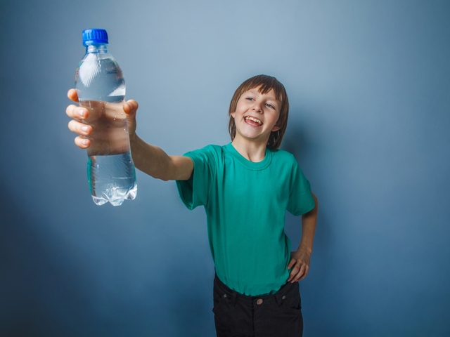 Junge mit einer Wasserflasche in der Hand