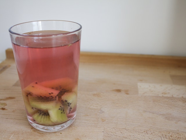 Wasserglas mit Kiwi und Hagebutte